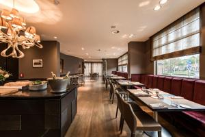 a dining room with long tables and chairs at Hotel De Notelaer in Bornem