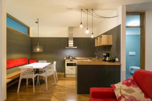 a kitchen and living room with a table and chairs at Laubenapartment in Merano
