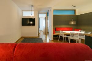 salon z czerwoną kanapą i stołem w obiekcie Laubenapartment w Meranie