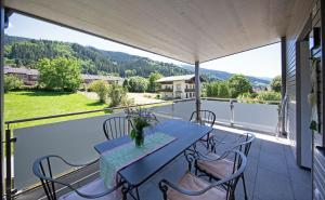 a patio with a table and chairs on a balcony at Ferienwohnungen Waltraud Trinker, Haus in Haus im Ennstal