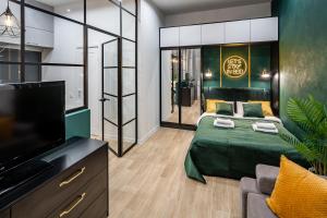 ein Wohnzimmer mit einem Bett und einem Flachbild-TV in der Unterkunft Emerald Lux Apartment. LiveInLviv in Lwiw