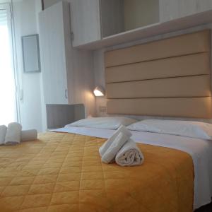 a hotel room with two beds with towels on the bed at Hotel Imperiale in Cesenatico