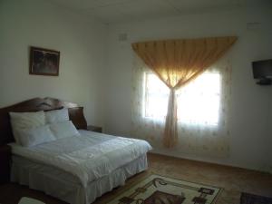 a bedroom with a bed and a window at Rainbow Guesthouse in East London