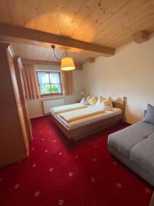 1 dormitorio con 2 camas y alfombra roja en Gästehaus Grauss, en Thiersee