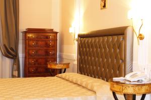 a bedroom with a bed and a dresser with a telephone at Boutique Hotel Trevi in Rome