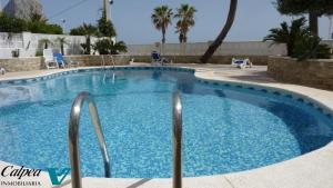 a swimming pool with blue water in a resort at Porto Azul 10A Frontal Peñon & Sea View First Line Arenal Beach in Calpe