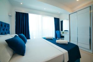 1 dormitorio con 1 cama grande con almohadas azules en Hotel Ambiente Ulcinj, en Ulcinj