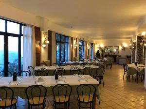 a dining room with tables and chairs and windows at Hotel Villa San Giovanni in Erice