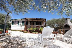 two lawn chairs and a house with a gazebo at Olive garden Trogir - mobil home in Trogir