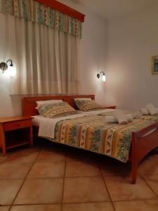 a bedroom with two beds and a table and a window at Nostos Studios Golden Beach in Chrysi Ammoudia