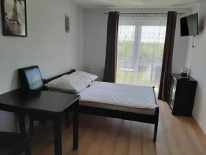 a bedroom with a bed and a chair and a window at Nad Stawem 2 in Sarbinowo