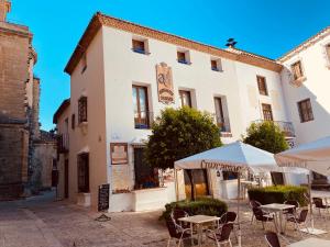 a building with tables and umbrellas in front of it at La Colegiata De Ronda in Ronda