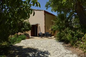 a stone walkway leading to a house with two chairs at Agriturismo Masseria La Chiusa in San Giuseppe Iato