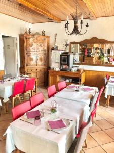 uma sala de jantar com duas mesas e cadeiras vermelhas em Le Sans Souci em Jausiers
