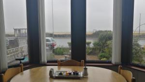 una mesa y sillas en una habitación con ventanas en Westleigh, en Morecambe