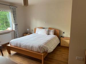 
a bed in a room with a wooden floor at Douglasha House V93RX64 in Killarney
