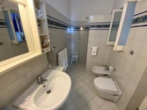 a white bathroom with a sink and a toilet at Basiluzzo Resort in Panarea