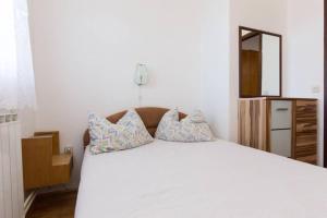 クルクにあるApartment with Terace and sea view Maricaのベッドルーム(白いベッド1台、枕、鏡付)