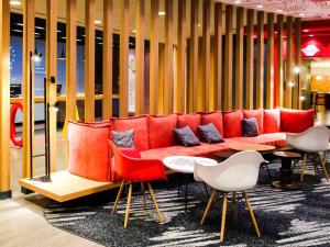 a red couch in a room with a table and chairs at ibis Sao Paulo Paulista in São Paulo