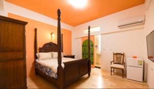 una camera con letto a baldacchino e sedia di Chi Chi B&B a Tainan