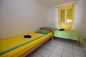 two twin beds in a room with a window at Apartman Rosa 2 in Kustići