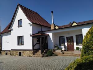 a white house with a red door at Penzion Burda in Sepekov