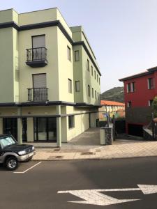 un bâtiment avec une voiture garée sur un parking dans l'établissement Luján 5E y 7G entre senderos y playas, laurisilva y plataneras, à Puntallana