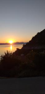 a sunset over a body of water with the sun at New studio app for 2 in Babino Polje