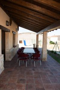 a patio with a table and chairs under a wooden ceiling at Casa Rural Consuelo in Torralba