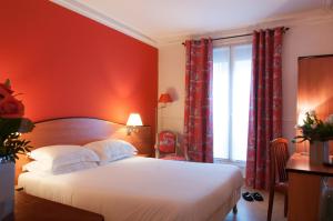 - une chambre avec un lit blanc et des murs rouges dans l'établissement Hotel Eden Montmartre, à Paris