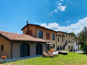 a large building with a yard with benches in front of it at Agriturismo PURO in Barga