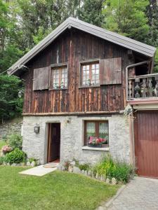 uma casa de madeira com janelas e uma garagem em Soggiorno Vacanze Stella Alpina em Temù