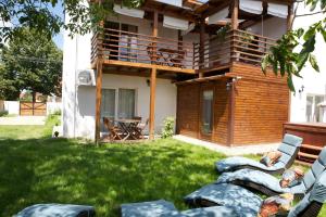 a backyard with a house with a deck and a patio at Sunset Apartments in Hajdúszoboszló