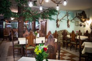 un comedor con mesas, sillas y árboles en Hubert Varga, en Komárno