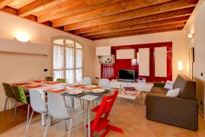eine Küche und ein Wohnzimmer mit einem Tisch und Stühlen in der Unterkunft Borgo del Torchio E6 in Manerba del Garda