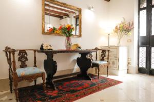 um quarto com uma mesa e duas cadeiras e um espelho em Casa Vacanze Angolo 'Sconto em Veneza
