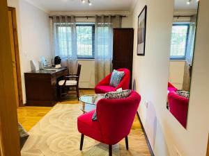 a living room with red chairs and a table at Millers House Boutique B&B in Emsworth