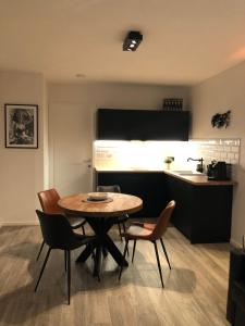 eine Küche und einen Tisch und Stühle in einem Zimmer in der Unterkunft De Konik in Uikhoven