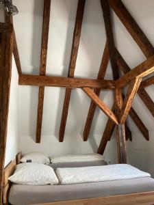 two beds in a room with wooden beams at Pension Zur Alten Post in Untermeitingen