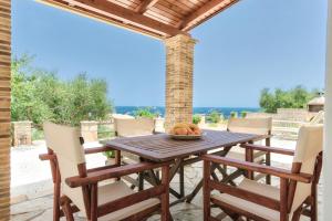 Une table et des chaises en bois sont disponibles sur la terrasse. dans l'établissement Villa Mare Studios, à Skinária