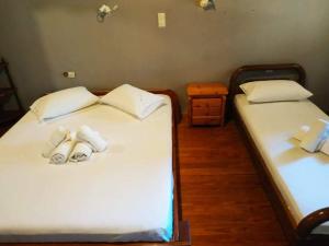two beds in a room with white sheets and towels at Lefkada Villas Panoramic in Katouna +41 photos