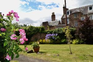 a garden with pink flowers in front of a house at Camlann in Alyth