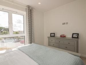 - une chambre blanche avec un lit et une fenêtre dans l'établissement Watergate View, à Newquay