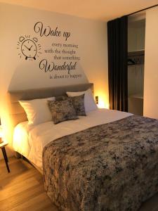ein Schlafzimmer mit einem Bett mit einer Uhr an der Wand in der Unterkunft De Konik in Uikhoven