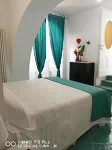 een slaapkamer met een bed met blauwe gordijnen en een raam bij Amalfi Small Wonder Tiny Town House in Amalfi