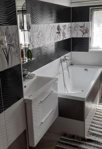 uma casa de banho com um lavatório e uma banheira em Fleurs de Mýto em Mýto pod Ďumbierom