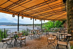 a group of tables and chairs with a view of the water at Complex Chayka Guest House in Byala