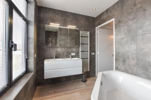 a bathroom with a white tub and a sink at Royaal appartement in het centrum van Yerseke in Yerseke +27 photos