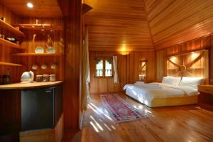 ein Schlafzimmer mit einem Bett in einem Holzzimmer in der Unterkunft Cirali Armira Bungalow in Cıralı