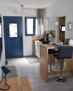 une cuisine avec une porte bleue, une table et des chaises dans l'établissement 4Bro Rooms Laerma Village, à Láerma